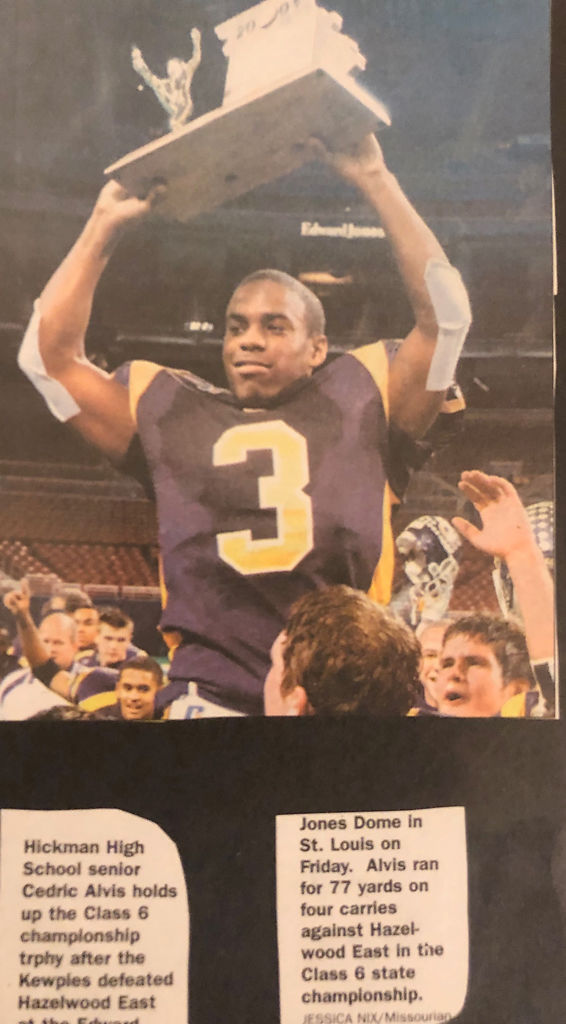 A newspaper clipping of Cedric Alvis holding up the Class 6 championship trophy